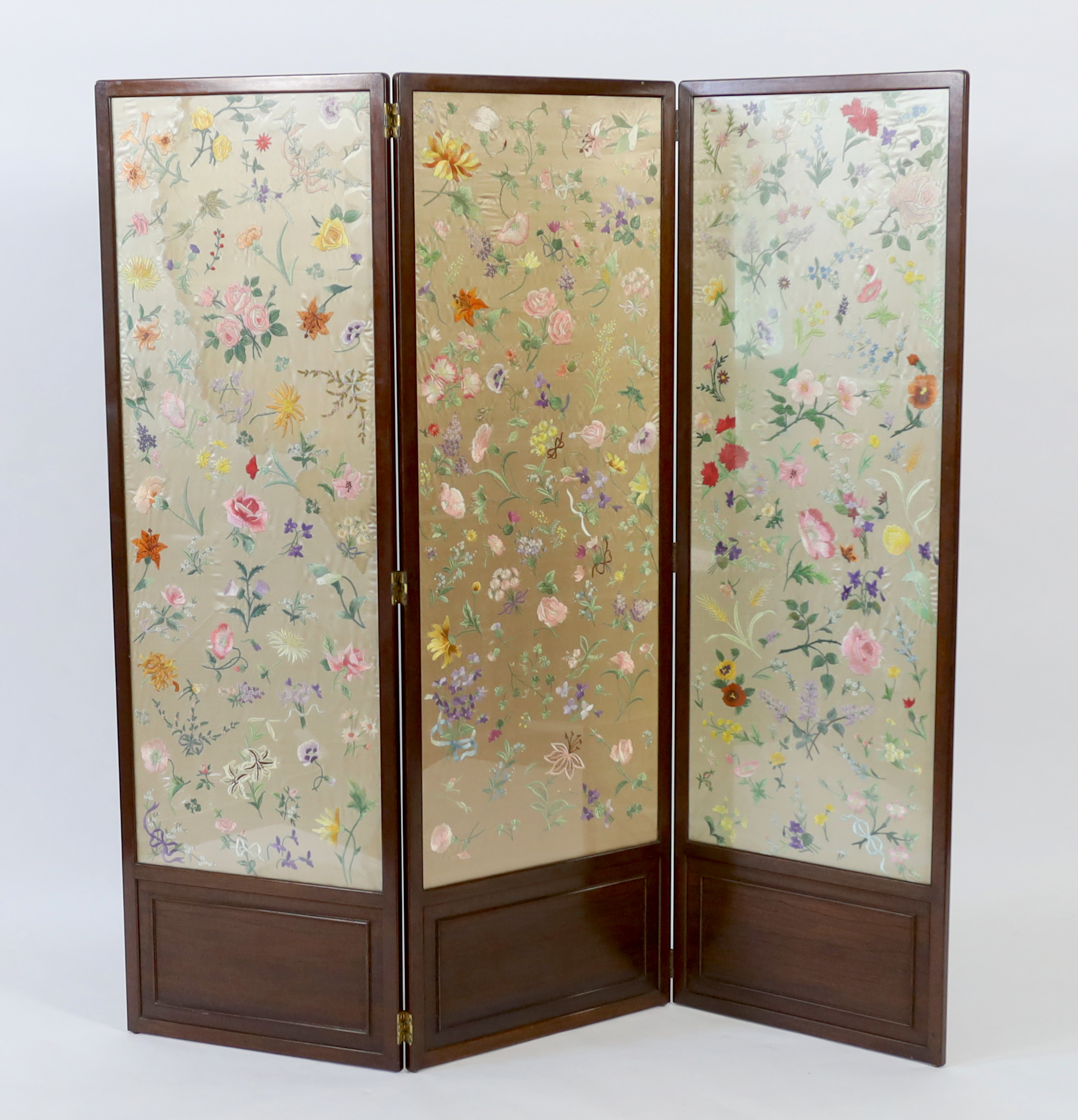 An Edwardian mahogany three fold screen with three panels of later (possibly 1920’s) hand embroidered, multi coloured, silk flowers, 50.5cm wide x 139cm high